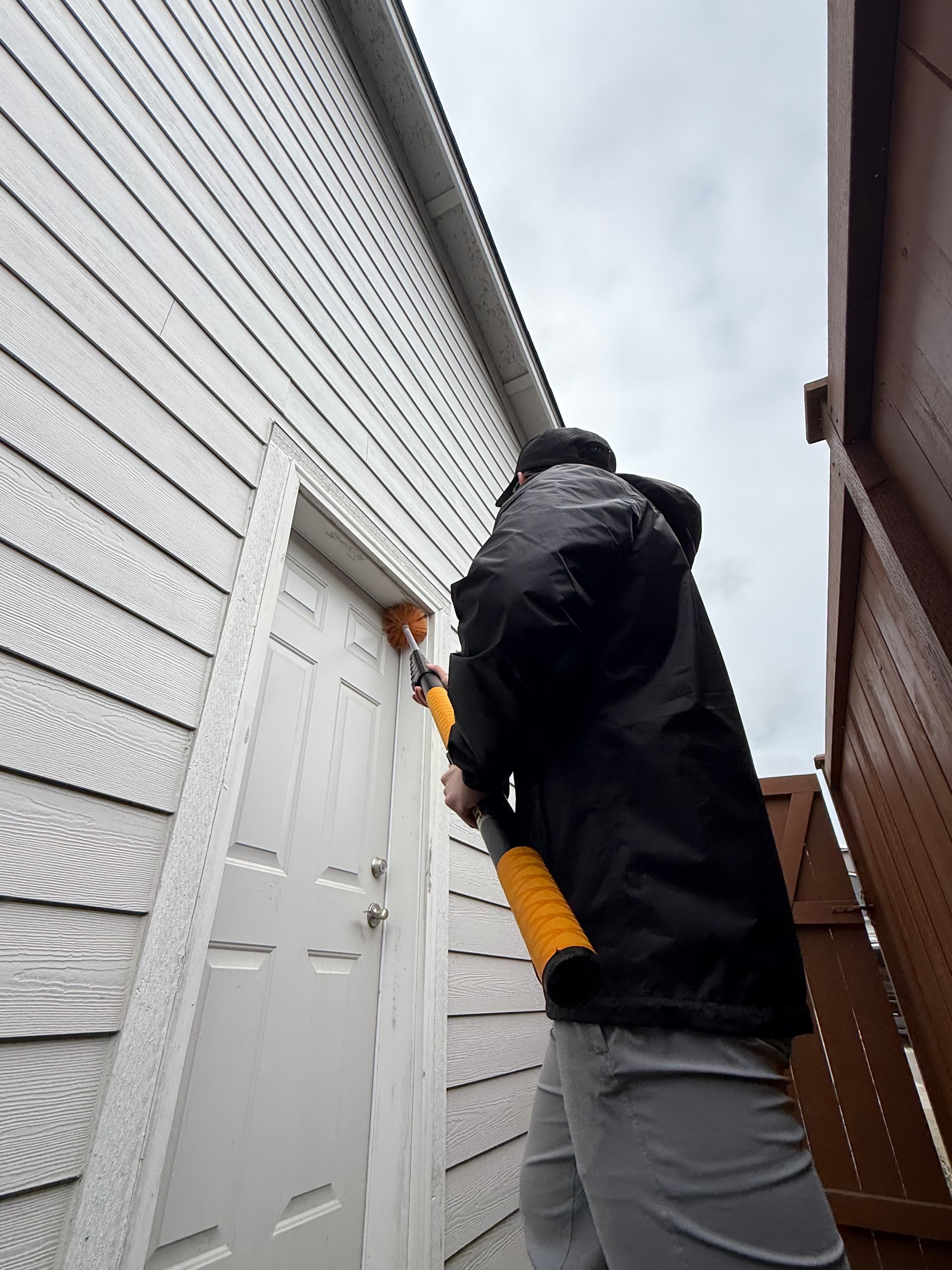 Technician performing seasonal specialty treatment at a home